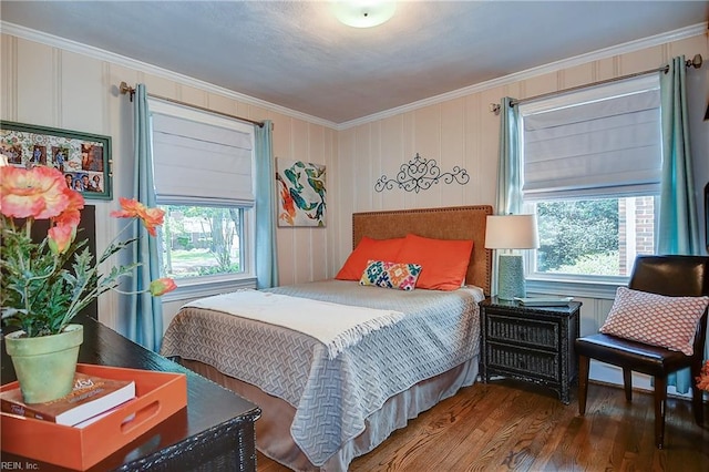 bedroom featuring multiple windows, ornamental molding, and wood finished floors