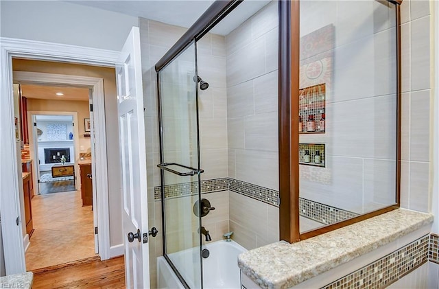 bathroom featuring combined bath / shower with glass door and wood finished floors