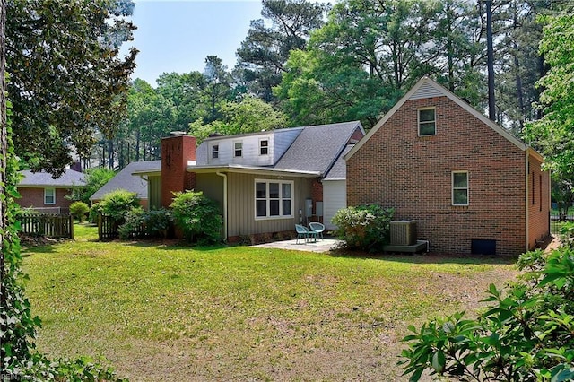 back of house featuring a lawn, fence, a patio area, and central AC