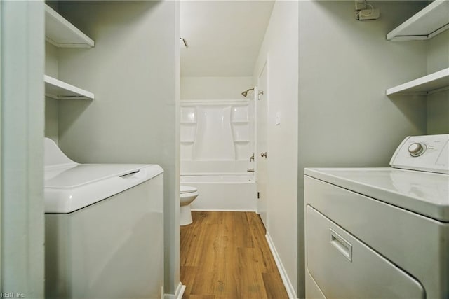 washroom featuring laundry area, light wood-style flooring, baseboards, and separate washer and dryer