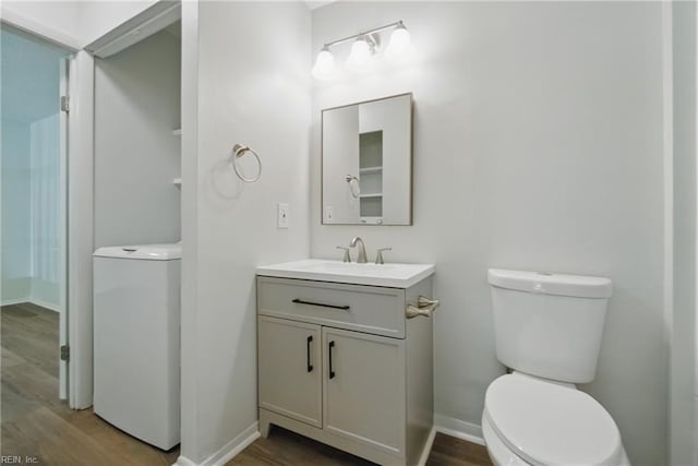 bathroom with vanity, baseboards, toilet, and wood finished floors