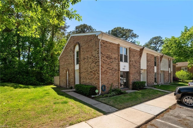view of home's exterior with brick siding and a yard