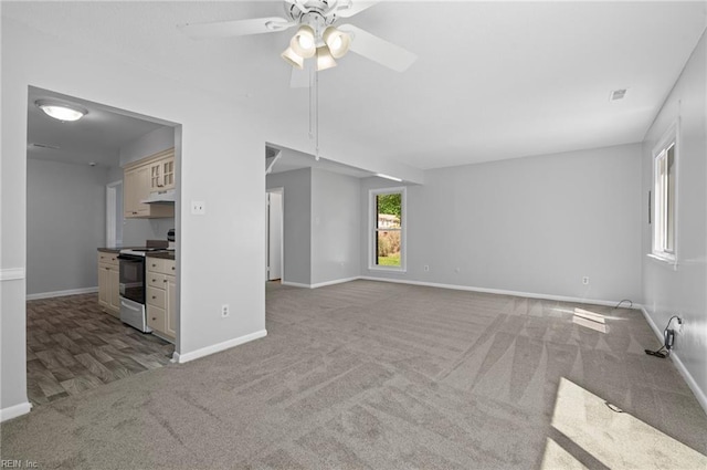 unfurnished living room with baseboards, a ceiling fan, carpet, and visible vents