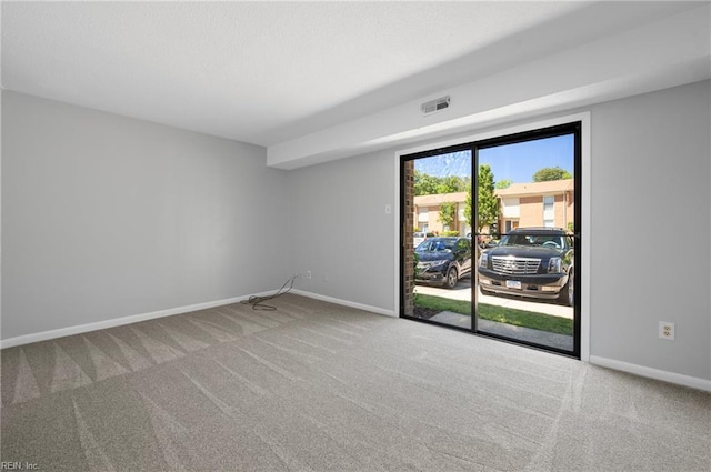 unfurnished room featuring baseboards, visible vents, and carpet