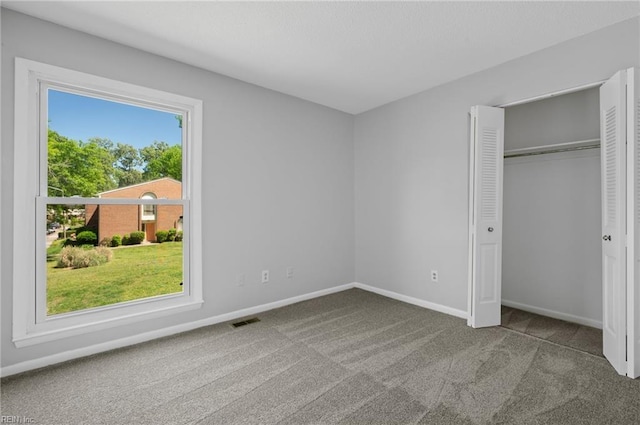 unfurnished bedroom with carpet flooring, baseboards, visible vents, and a closet