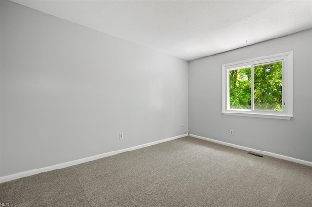 carpeted empty room with baseboards and visible vents