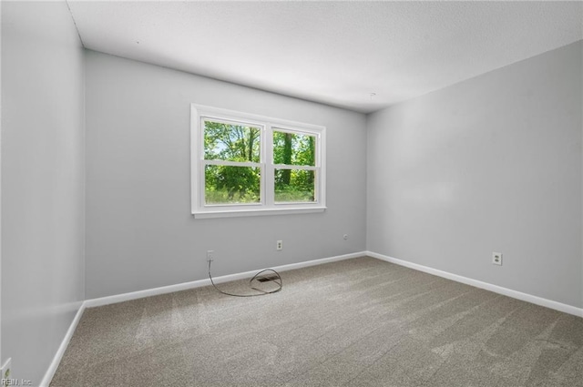carpeted empty room with baseboards