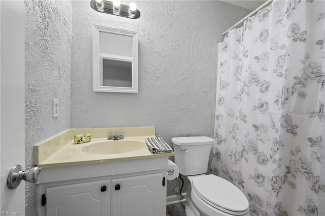 full bath with vanity, a textured wall, curtained shower, and toilet