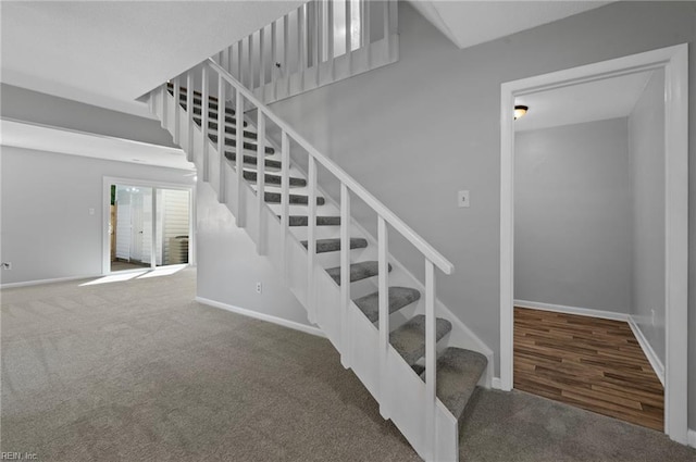 stairs with baseboards and carpet