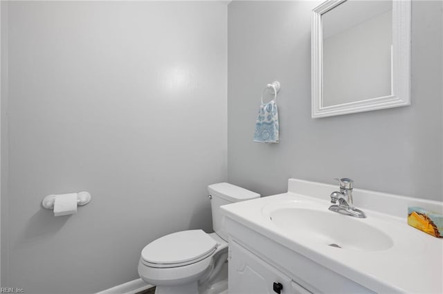 half bathroom featuring vanity and toilet