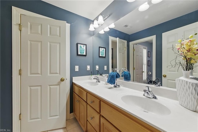 bathroom with a sink, tile patterned flooring, double vanity, and visible vents