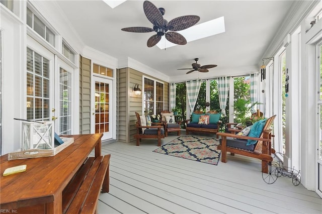 sunroom featuring a skylight, ceiling fan, and an outdoor hangout area