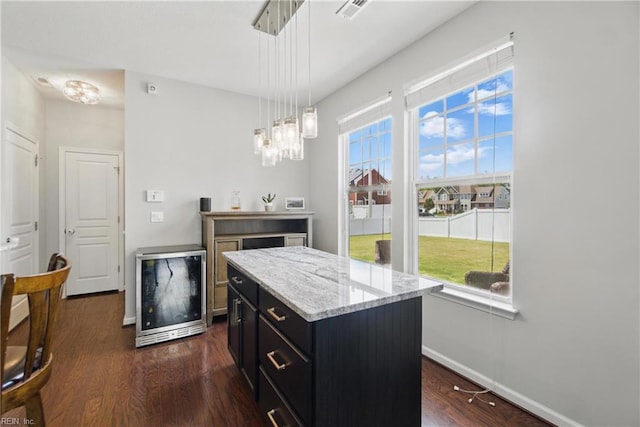kitchen with dark cabinetry, decorative light fixtures, baseboards, wine cooler, and dark wood-style floors