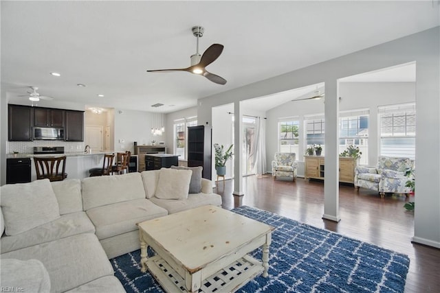 living area featuring dark wood-type flooring, a ceiling fan, lofted ceiling, and recessed lighting