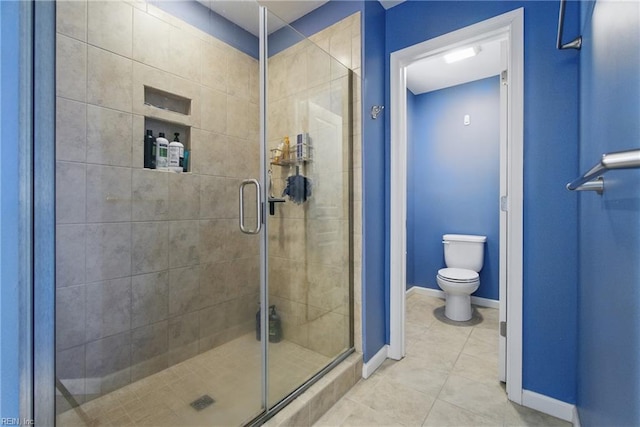 bathroom with tile patterned floors, baseboards, a shower stall, and toilet