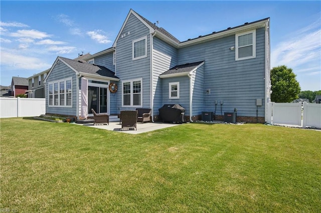 back of property with a lawn, a patio, central AC unit, and a fenced backyard