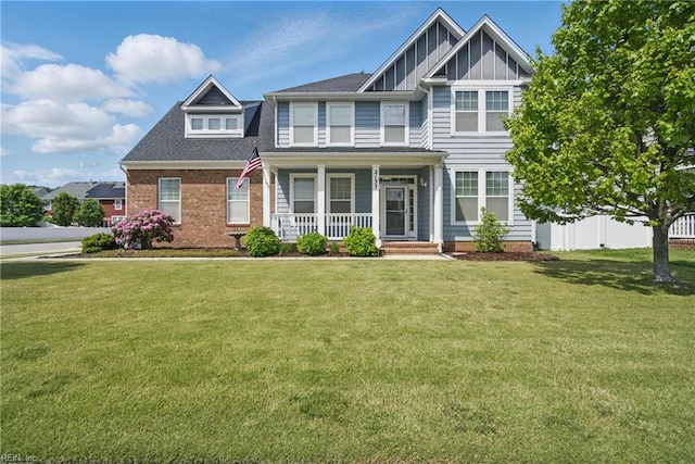 craftsman house featuring board and batten siding, fence, covered porch, and a front lawn