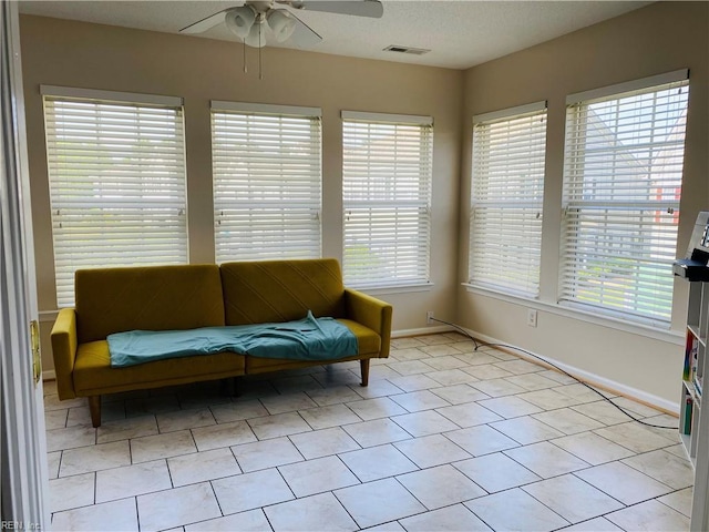 sitting room with visible vents, baseboards, and ceiling fan