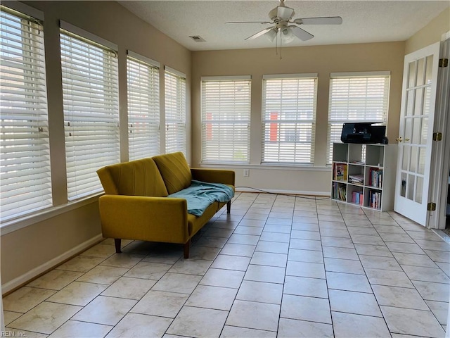 sitting room featuring a healthy amount of sunlight, ceiling fan, light tile patterned flooring, and visible vents