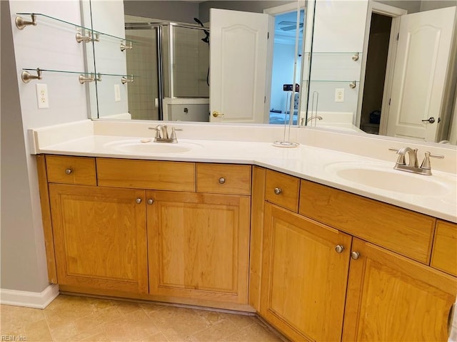 full bathroom featuring double vanity, a sink, and a stall shower