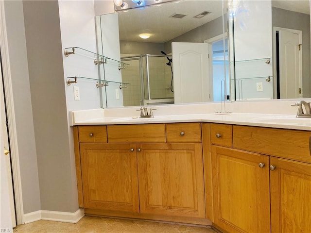 bathroom with visible vents, a sink, and a shower stall