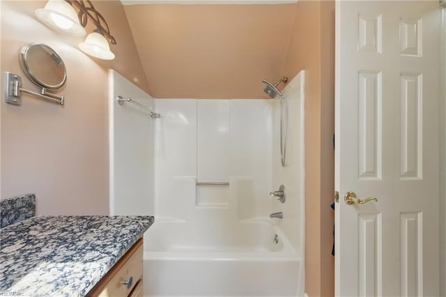 bathroom with shower / washtub combination, vanity, and lofted ceiling