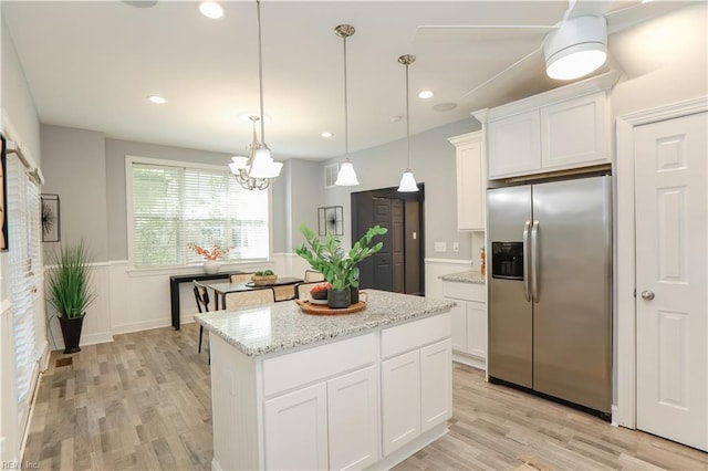 kitchen featuring stainless steel fridge with ice dispenser, white cabinets, a wainscoted wall, and light wood-type flooring