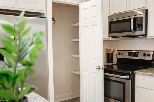 kitchen featuring appliances with stainless steel finishes, backsplash, and white cabinetry