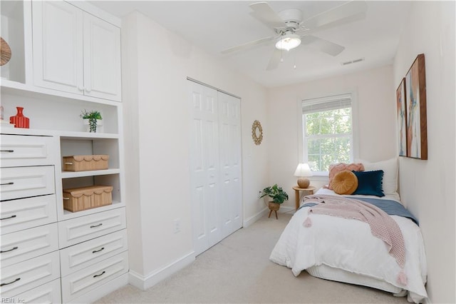 bedroom with visible vents, a closet, light carpet, baseboards, and a ceiling fan