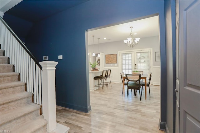 interior space featuring light wood finished floors, stairs, and a notable chandelier