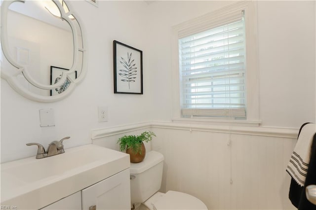 bathroom with vanity, wainscoting, and toilet