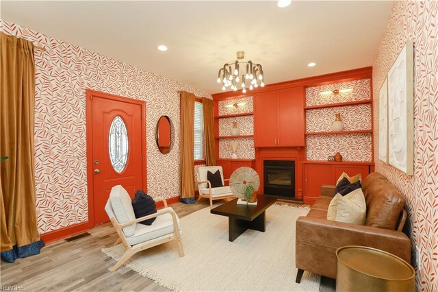 living area with recessed lighting, wallpapered walls, an inviting chandelier, and light wood-type flooring