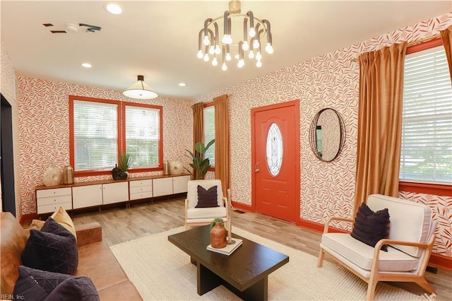 living area with recessed lighting, wallpapered walls, wood finished floors, and a chandelier