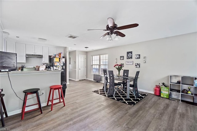 dining area featuring baseboards, ceiling fan, and wood finished floors