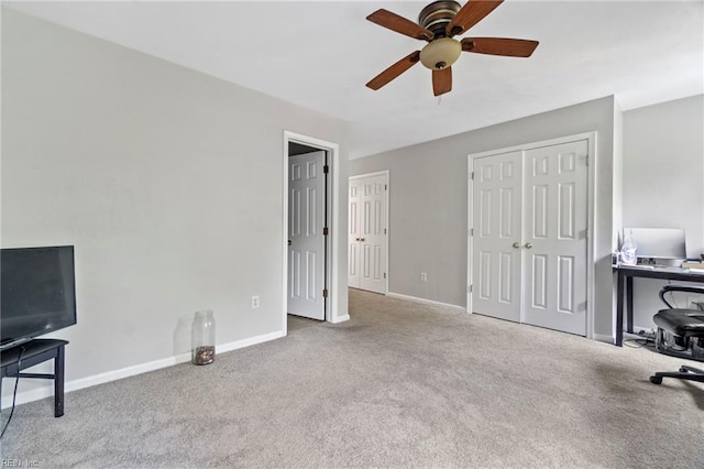 unfurnished office featuring baseboards, a ceiling fan, and carpet flooring