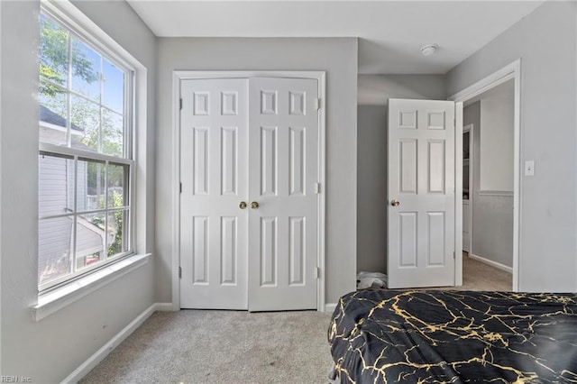 bedroom with a closet, carpet flooring, and baseboards