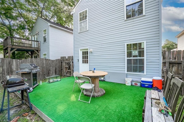 rear view of property featuring a fenced backyard, a wooden deck, and a yard