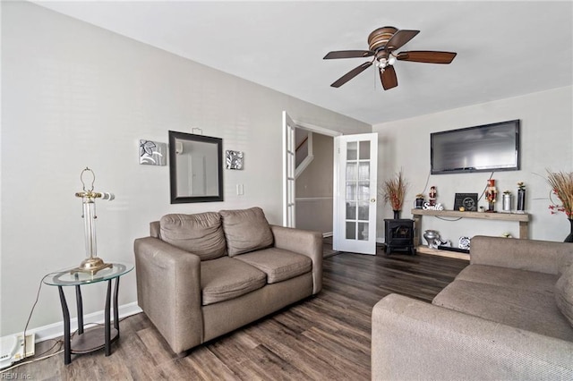 living room featuring baseboards, a ceiling fan, and wood finished floors