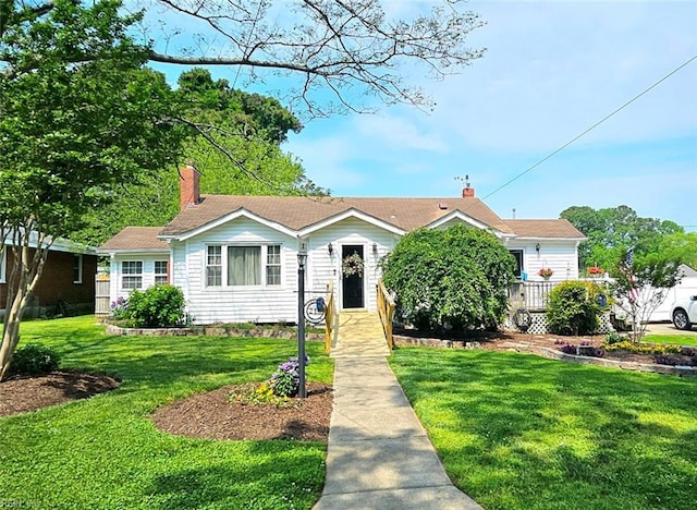 view of front facade with a chimney and a front yard
