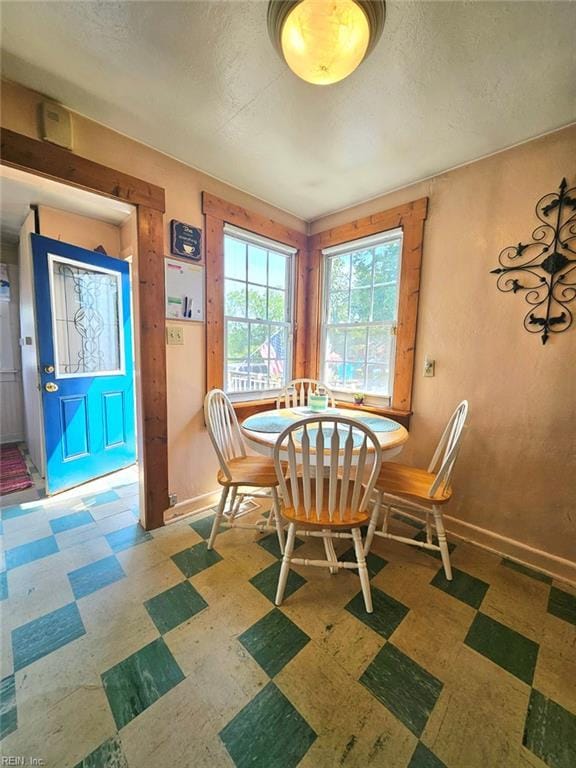dining area featuring baseboards, a textured ceiling, and tile patterned floors