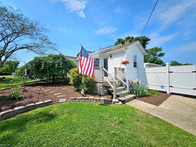 shotgun-style home with a chimney, a gate, fence, and a front yard