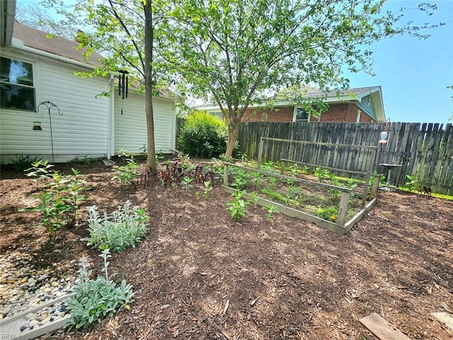 view of yard featuring fence and a garden