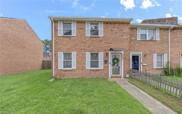 view of property featuring brick siding, fence, cooling unit, and a front lawn