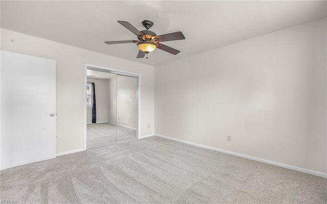 empty room featuring light colored carpet, baseboards, and ceiling fan