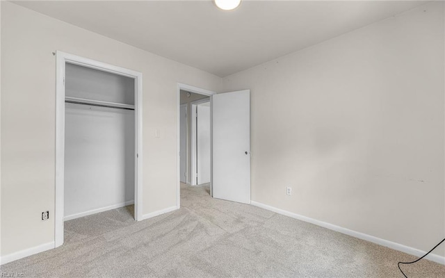 unfurnished bedroom featuring carpet floors, baseboards, and a closet