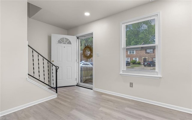 foyer featuring stairs, baseboards, and wood finished floors