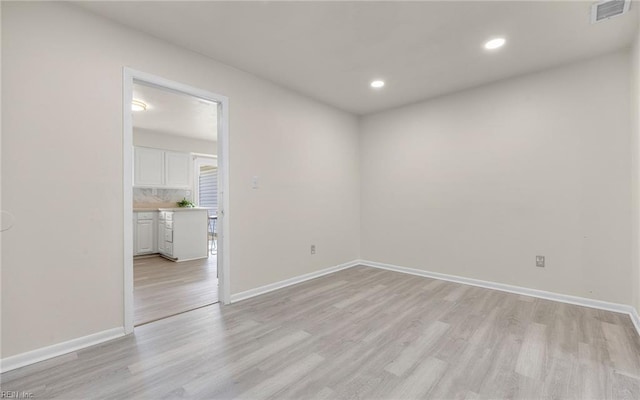 unfurnished room featuring recessed lighting, baseboards, light wood finished floors, and visible vents