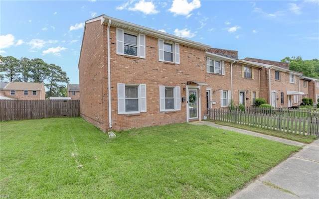 view of front facade featuring brick siding, fence private yard, and a front lawn