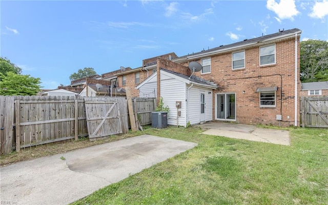 back of property with a patio, a gate, and brick siding