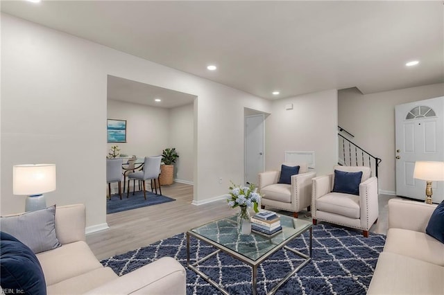 living room with recessed lighting, baseboards, stairs, and wood finished floors